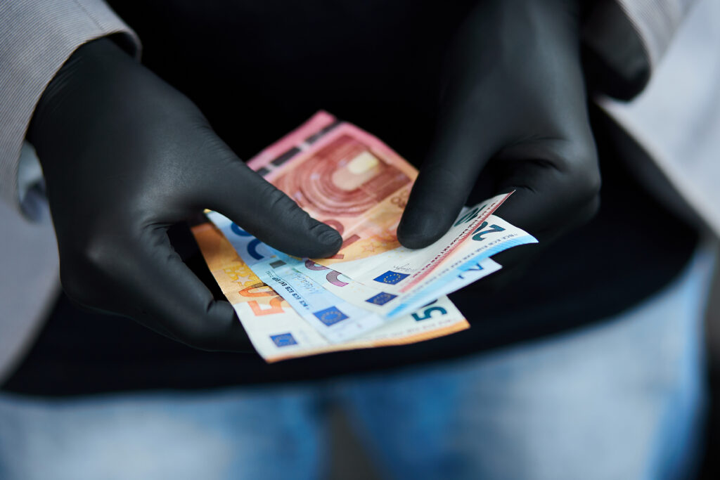 Person hält Euro-Geldscheine, symbolisierend das Krankentagegeld der betrieblichen Krankenversicherung, das bei längerer Krankheit finanziellen Schutz bietet."