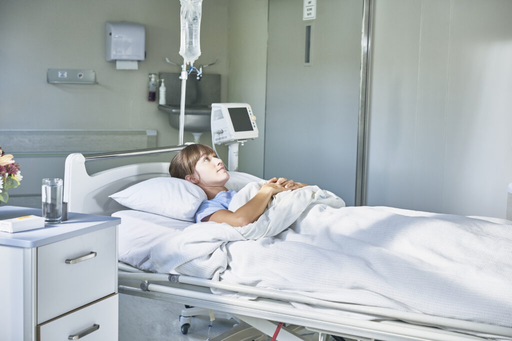 Patientin im Krankenhausbett, symbolisierend den Versicherungsschutz der betrieblichen Krankenversicherung bei Krankenhausaufenthalten und Krankenhaustagegeld.